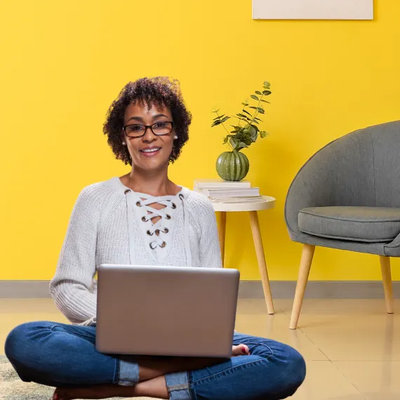 woman sitting on floor using laptop